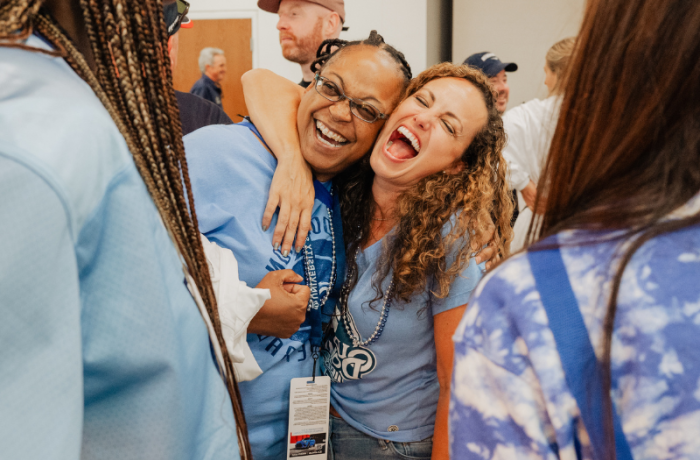 Two women hugging and laughing